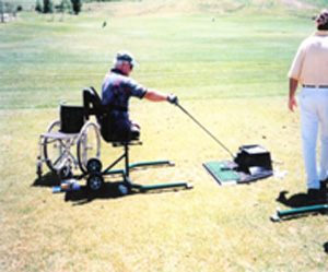 A double amputee plays golf using automated ball teeing devices.