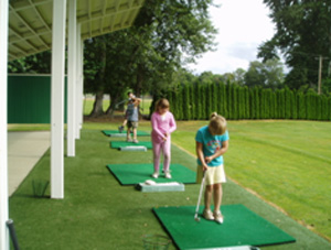 Young children playing golf.