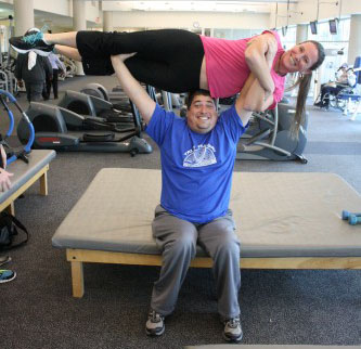 Raymond is lifting Kelly over his head