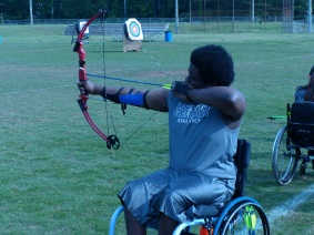 a participant competes in an archery event, shooting from a wheelchair