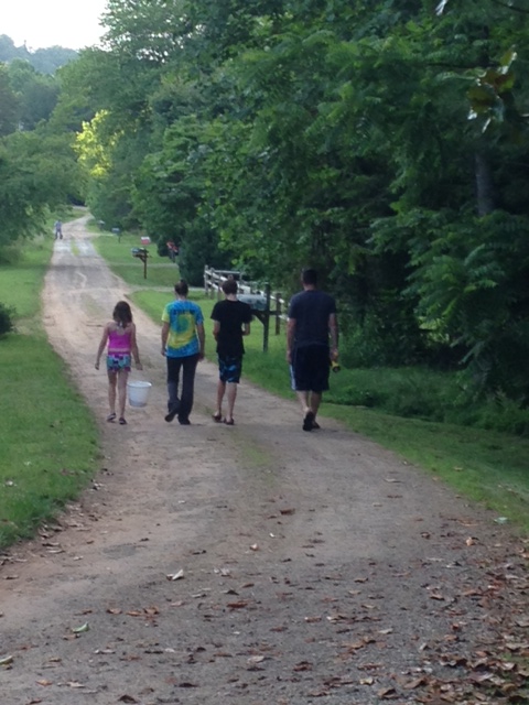 4 kids walk down a dirt road together