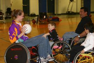 Image of wheelchair users of various ages playing wheelchair basketball