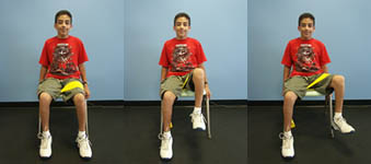 Child with Spina Bifida is performing a Hip Abduction exercise from a seated position.